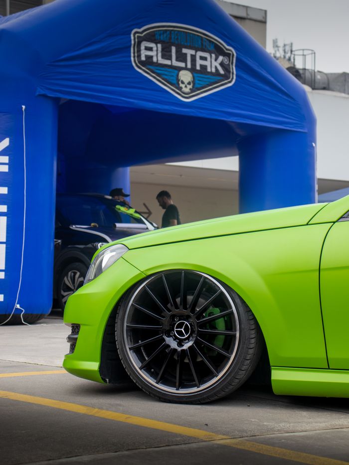 services-bg Close-up of a vibrant green luxury car at an auto exhibition, showcasing custom wheels and branding.
