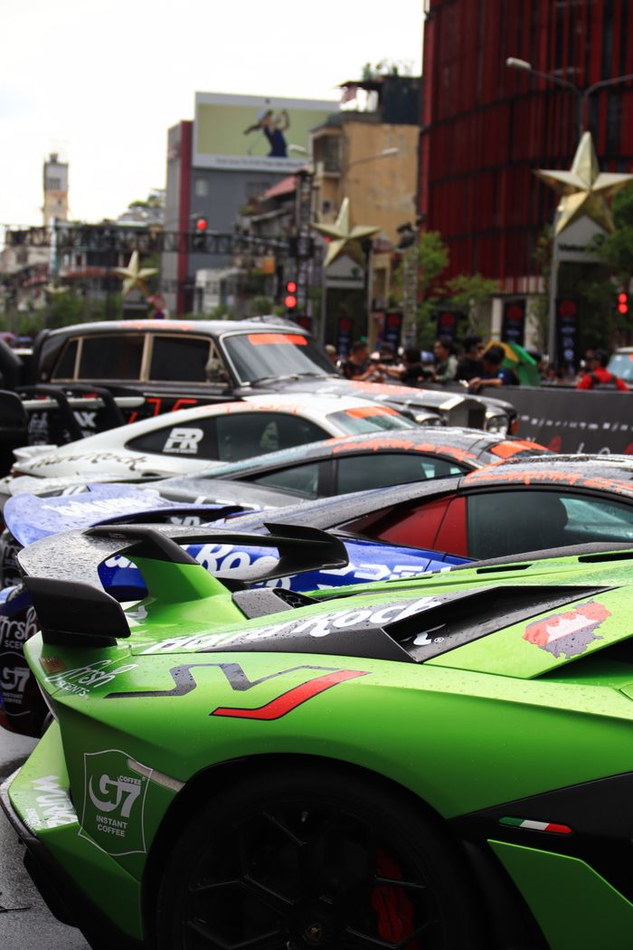services-01 Vibrant lineup of sports cars on a bustling city street with iconic buildings.